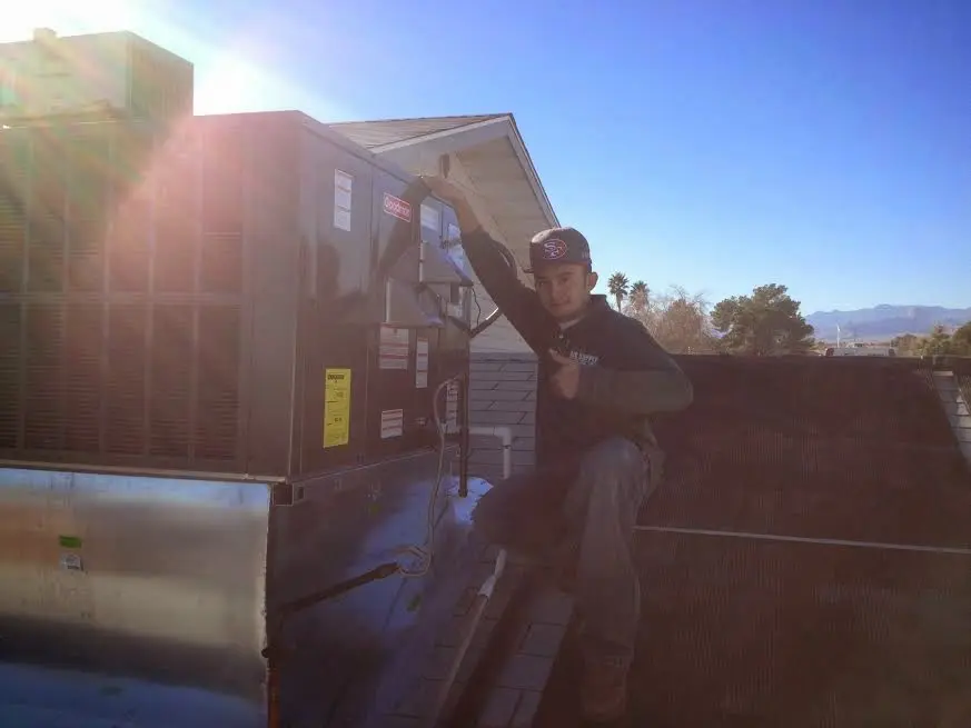 HVAC technician performing AC Tune-Up on a rooftop unit in Friendly